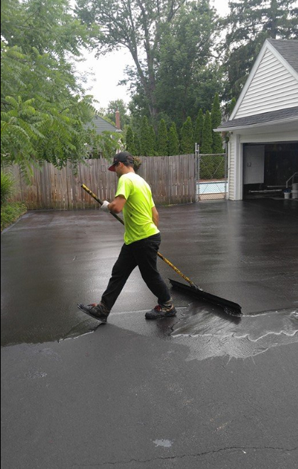 sealcoating services being applied to driveway